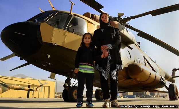 Latifa and Malalai Nabizada standing in front of a helicopter