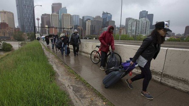Residents leave the flooding downtown core as new orders evacuating all of downtown were issued in Calgary, Alberta 21 June 2013