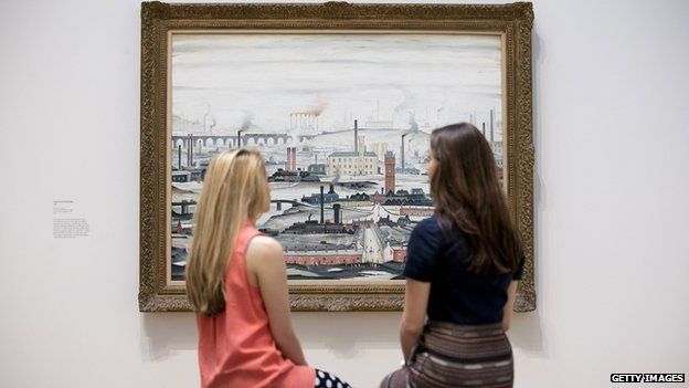 Museum employees pose for a picture in front of English artist Laurence Stephen Lowry's painting 'Industrial Landscape 1955' at the Lowry and the Painting of Modern Life exhibition at Tate Modern