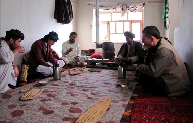 Men sitting cross-legged, sharing a breakfast