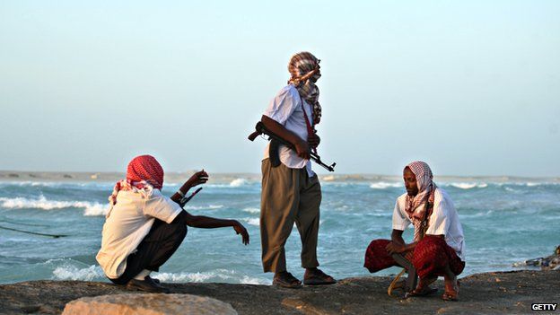 Armed pirates keep watch on the Somali coast in 2010