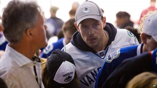 Cory Monteith, right, and Lea Michele, in cap, attend a National Hockey League match between the Vancouver Canucks and San Jose Sharks in Vancouver, Canada, 1 May 2013