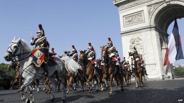 Republican Guard riders pass the Arc de Triomphe on the annual Bastille Day parade in Paris, 14 July 2013