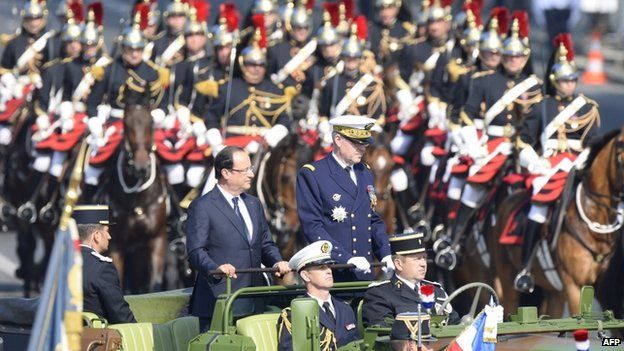 Paris military governor, general Herve Charpentier (r) and French President Francois Hollande review the troops during the Bastille Day parade on the Champs Elysees 14 July