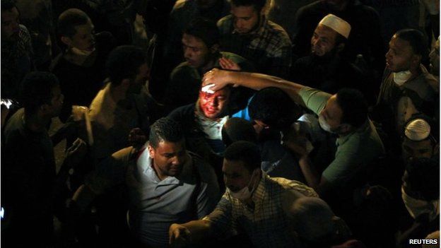 An injured man in crowds in Cairo (15 July 20130