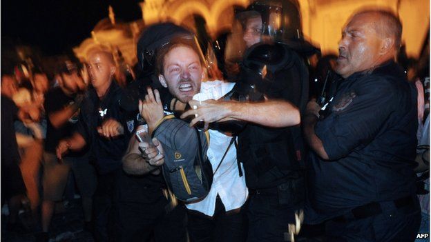 Bulgarian riot policemen push a protestor during an anti-government protest in Sofia on July 23, 2013