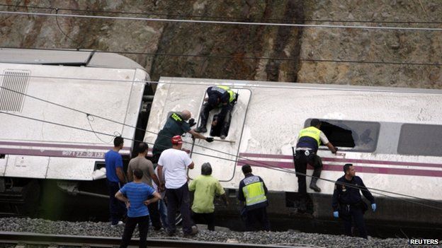 Rescue workers search for victims inside overturned train carriage on 24 July 2013