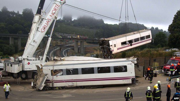 A crane removes one of the derailed train carriages at the site of a train accident near Santiago de Compostela