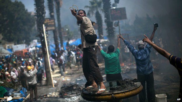 A supporter of ousted Islamist President Mohammed Morsi shoots a slingshot at Egyptian security forces