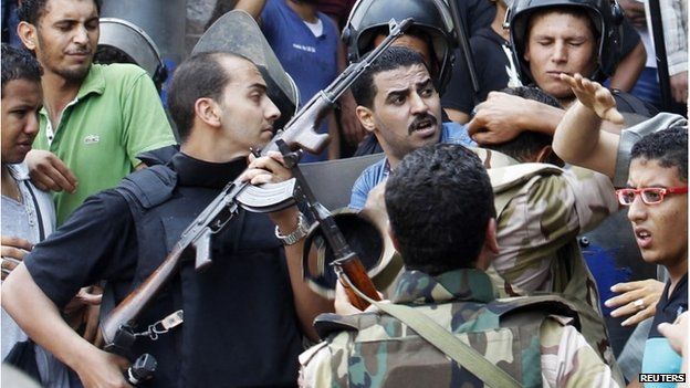 Police and pro-Egyptian government supporters struggle outside al-Fath mosque