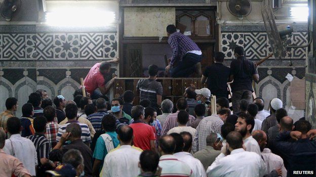 Demonstrators in support of ousted Egyptian President Mohammed Morsi wait by the barricaded door inside al-Fath mosque at Ramses Square in Cairo (17 August 2013)