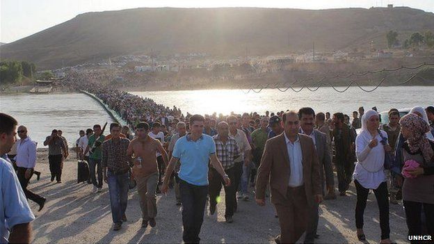 Syrians stream across the new pontoon bridge over the Tigris on 15 August 2013