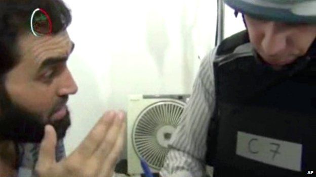 Image taken from amateur video footage, a UN inspector, right, speaks to a man about the alleged chemical weapon attack at a makeshift hospital in Muadhamiya, Damascus, on 26 August 2013