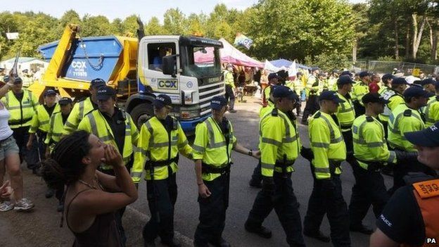 Police escort a lorry arriving at the site