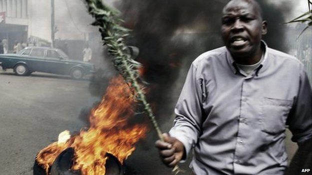 A man demonstrates beside a burning tyre during a demonstration in Eldoret 16 January 2008 in western Kenya.