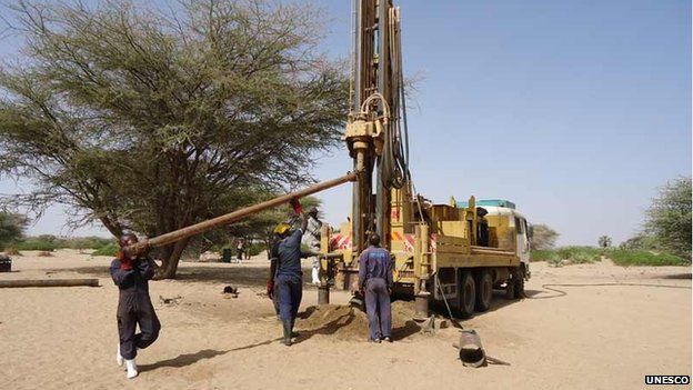 Drilling technicians loading an extra drilling rod to the drilling rig, Turkana, Kenya