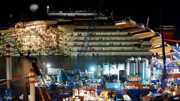 The wreck of Italy's Costa Concordia cruise ship begins to emerge from water on 17 September 2013 near Giglio port