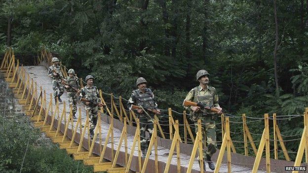 Border Security Force soldiers patrol a footbridge over a stream near the Line of Control (LoC) in Poonch district, on August 8, 2013