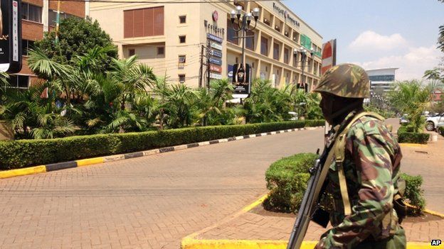 A soldier moves to take up a position outside an upscale shopping mall, seen background, in Nairobi, Kenya Saturday 21 September 2013.