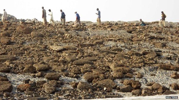 People walk on an island that rose from the sea following an earthquake, off Pakistan's Gwadar coastline in the Arabian Sea 25 September, 2013.