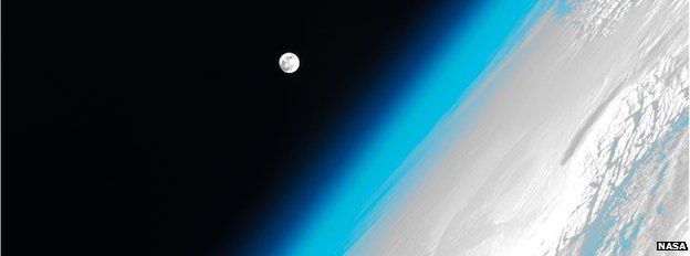 The Moon hovers Earth's atmosphere as seen from the International Space Station