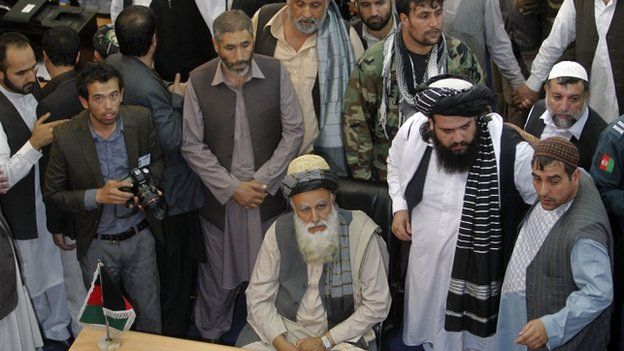 Afghan Mujahideen leader Abdul Rassoul Sayyaf (C, seated) waits to register as a candidate for the presidential election at Afghanistan"s Independent Election Commission (IEC) in Kabul October 3, 2013.