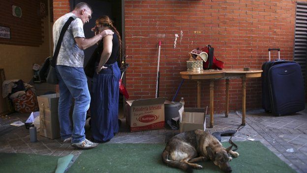An anti-eviction activist comforts Maria Isabel Rodriguez Romero as she packs her family's belongings outside her apartment, where they had been camping out for a week and a half after their eviction in Madrid, 5 October