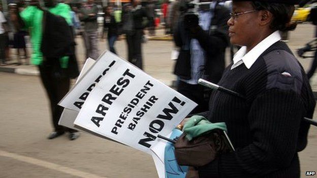 A Kenyan police officer carries confiscated placards in the Kenyan capital, Nairobi, calling for the arrest of Sudan's President Omar al-Bashir on 27 August 2010