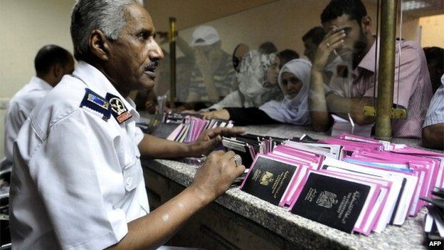 Egyptian custom officials check passports and identity cards as travellers wait on Egyptian side of the Rafah border crossing point on 10 August 2012