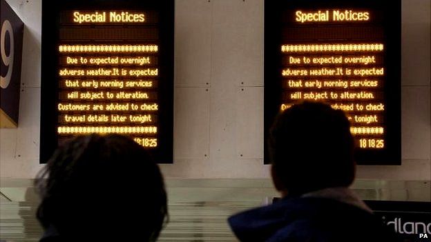 Rail passengers at Euston station looking at signs