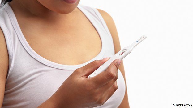 A woman checking a pregnancy test