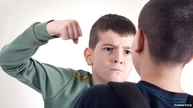 A boy threatening another boy