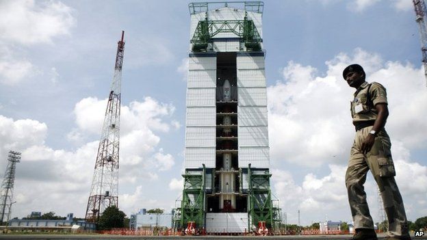 A paramilitary soldier walks past the Polar Satellite Launch Vehicle (PSLV-C25) at the Satish Dhawan Space Center at Sriharikota, in the southern Indian state of Andhra Pradesh, Wednesday, Oct. 30, 2013.