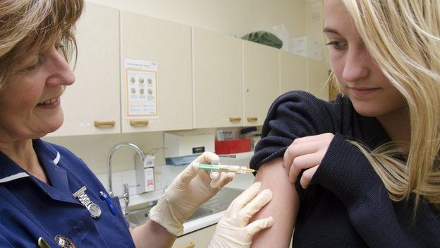 Nurses vaccinating a girl with the HPV jab