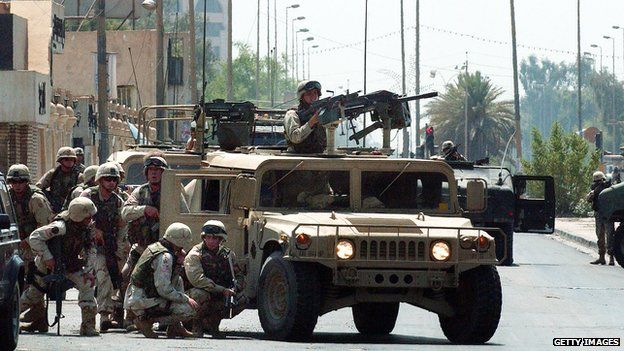 US troops take cover during a gun battle in Baghdad, 7 August 2003