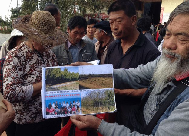 Villagers display photos of land grabs in Jinning County, Yunnan Province