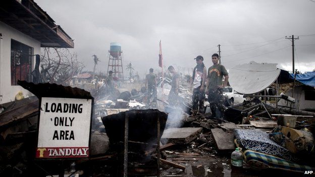 Filipino military personnel stand by a building damaged by typhoon Haiyan at the airport in Tacloban, on the eastern island of Leyte on 12 November 2013