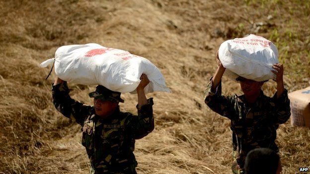 Philippine soldiers carry relief goods to be given to typhoon survivors in Tacloban, Leyte province, central Philippines on 13 November 2013