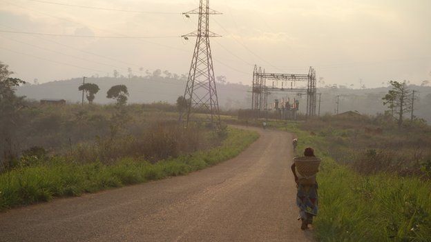 A person walking past power lines near Inga dam, DR Congo