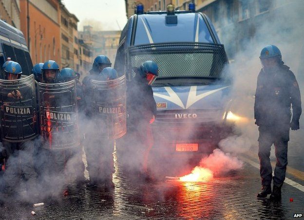 A policeman clears away a flare during a confrontation with students in Rome, 15 November