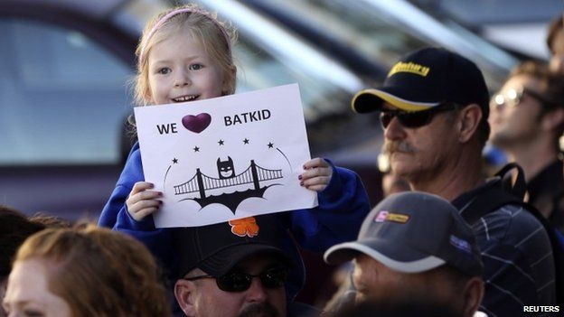 Kayla Fry holds a sign as she waits to see five-year-old leukemia survivor Miles Scott in San Francisco on 15 November 2013