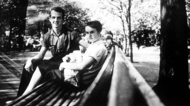 Lee Harvey Oswald and his wife on a park bench, with baby