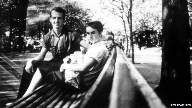 Lee Harvey Oswald and his wife on a park bench, with baby