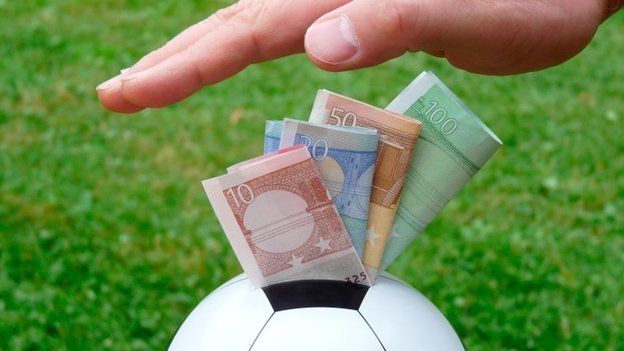 Money being stuffed into a football