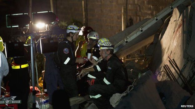 Emergency workers are seen during their search for survivors after a building collapsed in Tongaat