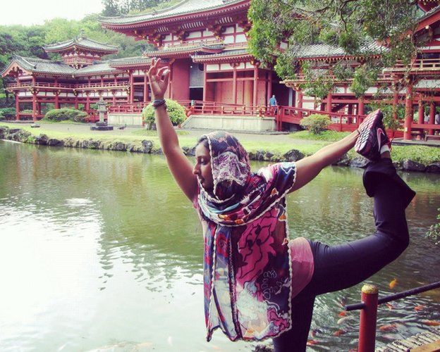 Farida Hamza doing a yoga pose near a lake