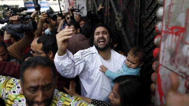 Egyptian pro-democracy activist and opponent of Egypt's ruling Muslim Brotherhood, Alaa Abd Fattah, arrives at the general prosecutor office in Cairo holding his son on March 26, 2013, to turn himself in for questioning, a day after an order for his arrest