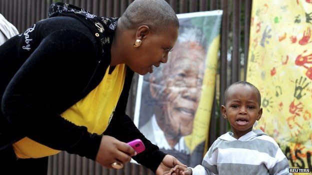 Mother consoles son as they mourn outside Mandela house in Soweto