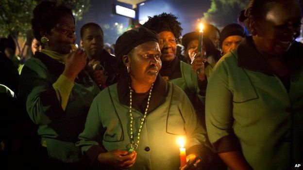 Members of the African National Congress (ANC) Womens League hold candles and sings songs outside Mr Mandela's old house in Soweto