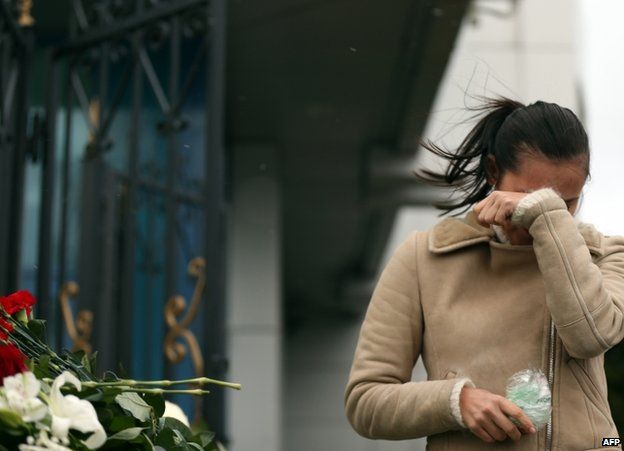 A woman weeps near a fence at Kazan airport, Russia, 18 November
